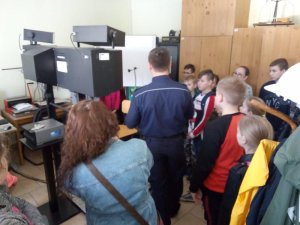 Dzieci oglądają maszynę do wykonywania fotografii osobom zatrzymanym