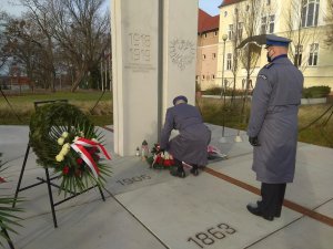 Policjanci oddają hołd przed pomnikiem Powstańców Wielkopolskich i składają kwiaty