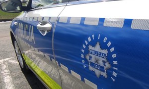 fotografia przedstawia drzwi boczne radiowozu z logo Policja Pomagamy i Chronimy