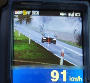 Widok monitora urządzenia pomiarowego, na którym widnieje pojazd z poruszający sie z prędkością 91 km/h
