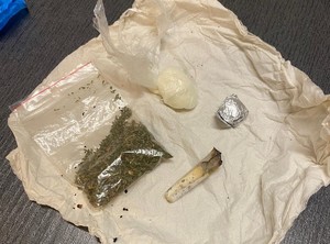 widok leżących na stole narkotyków - widać worek strunowy z marihuaną, woreczek z amfetaminą i zawiniętą srebrną kulkę