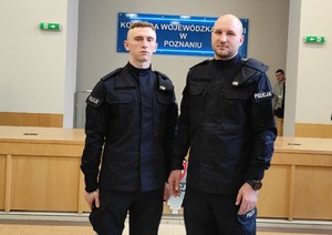 dwóch policjantów z Wągrowca stoi obok siebie, w tle napis komenda wojewódzka policji