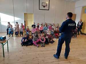 policjant stoi przed dziećmi i prowadzi zajęcia