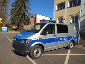 VW T6 stojący przed budynkiem komendy ujęcie z zewnątrz, widoczne są włączone błyski