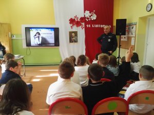 Dzielnicowi prowadzą zajęcia dla dzieci, dzieci na miejscach wysłuchują pogadanki aspiranta sztabowego Dariusza Szymczaka