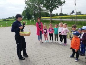 Policjantka przeprowadza rozmowę z dziećmi.