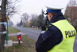 Policjant prowadzący kontrolę prędkości przy drodze wojewódzkiej