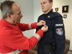 policjant ma przypinaną odznakę dawcy krwi
