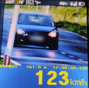 123 km/h wskazanie prędkości i widok pojazdu - czarny ford focus na urządzeniu pomiarowym
