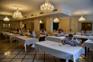 sala ze stołami, na niej kilkudziesięciu policjantów rozwiązuje testy