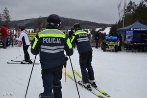 policjanci na nartach jadą po stoku