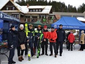 namiot reklamowy policji, wokół narciarz i policjanci, wszystko na dole stoku