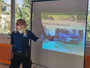 policjantka przy tablicy - ekranie pokazuje na prezentację