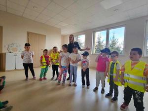 sala przedszkolna, policjantka stoi wśród dzieci