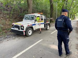 policjant na ulicy obok samochodu ratowniczego