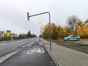 radiowóz stojący przy drodze, zdjęcie skupia się na drodze dla rowerów