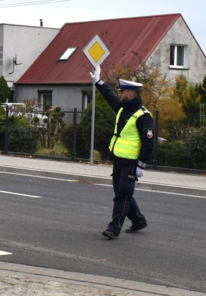 policjant wrd na drodze z uniesioną ręką zatrzymuje ruch