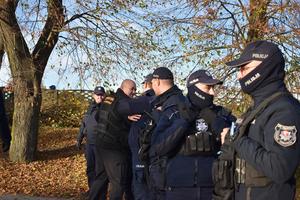 policjanci rozmawiaja z ochroniarzem koło stadionu