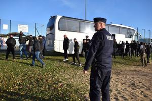 jeden z dowódców zabezpieczenia stoi przy autokarze z kibicami