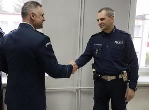 komendant wręcza rozkaz policjantowi i gratuluje powierzonego stanowiska