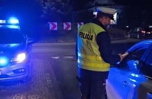 policjant z wydziału ruchu drogowego podaje urządzenie do badania trzeźwości kierowcy