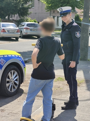 inne ujęcie policjantki i chłopca z hulajnogą