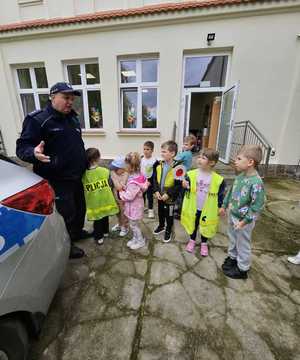 policjandci z dziećmi przy radiowozie