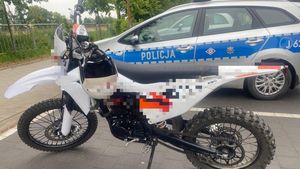 motocykl typu cross stoi obok zaparkowanego radiowozu.