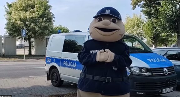 postać sierżanta pyrka na tle radiowozu policyjnego