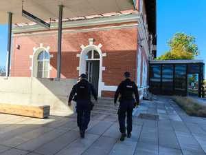 Policjanci patrolują okolice dworca , w tle budynek