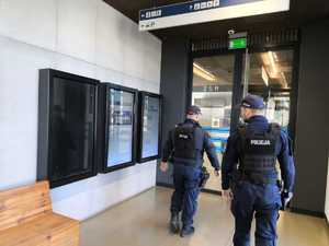 Policjanci patrolują budynek dworca, ida przez poczekalnie
