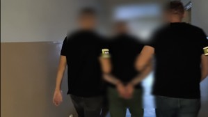 policjanci prowadzą jednego z zatrzymanych