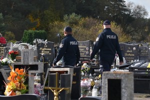 Policjanci patrolujący nekropolię, rozmawiają z ludź