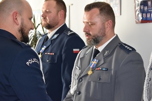 zdjęcia ze zbiórki, policjanci odbierają wyróżnienia- rozkazy, przypinane są im medale związkowe, a także pozują do zdjęć grupowych z przełożonym po otrzymaniu wyróżnień