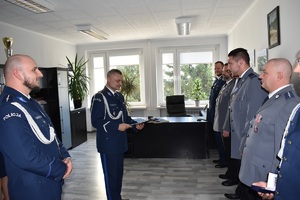 zdjęcia ze zbiórki, policjanci odbierają wyróżnienia- rozkazy, przypinane są im medale związkowe, a także pozują do zdjęć grupowych z przełożonym po otrzymaniu wyróżnień