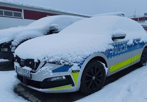 zaśnieżony radiowóz stoi na zaśnieżonym parkingu