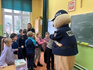 policjanci prowadzą zajęcia dla dzieci, fotografie podczas zajęć w klasach, grupowe z sierżantem pyrkiem, podczas robienia odcisków palców