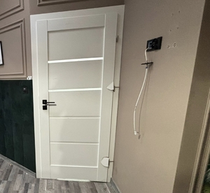 zdjęcia zniszczonych drzwi, toalety, wyposażenia kuchni, pokoju i zatrzymanego prowadzonego przez policjanta