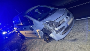 roztrzaskany pojazd , za nim stoi radiowóz, jest ciemno