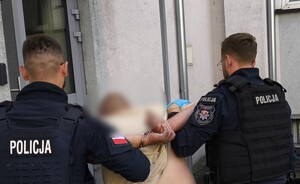policjanci z zatrzymanym i samochód na lawecie